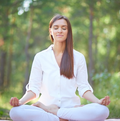 Woman sitting in meditation posture in nature